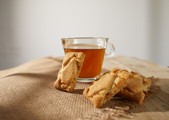 apple cookies with a cup of tea. pastry with drink. apple pie on the table. bakery on a sunny day. dessert serving on a table with wooden planks and burlap. rustic food.