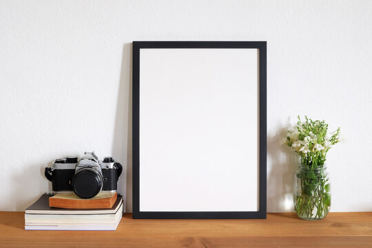 blank photo frame with film camera on table