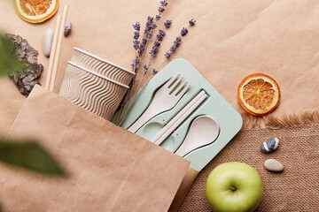 Plastic free, eco-friendly ecological dishes in reusable bag on crumpled paper. Sustainable...
