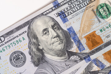  A close-up of a hundred dollar bill featuring Benjamin Franklin, the iconic symbol of American...