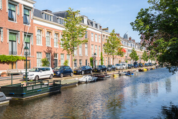 Row of brick townhouses along a canal on a clear summer day