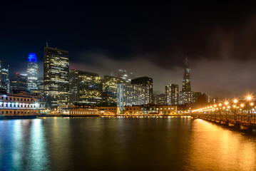 Fototapeta na wymiar San Francisco downtown skyline partly covered with fog at night in autumn