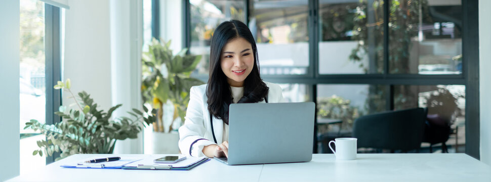 Asian businesswoman sit at their desks and calculate financial graphs showing results about their investments, plan a successful business growth process