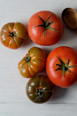 Variiety of red salad tomatoes on white kitchen board