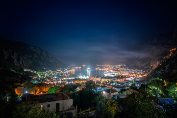Amazing night view of the picturesque Bay of Kotor with the illuminated streets, buildings and cruise ships at the harbor.
