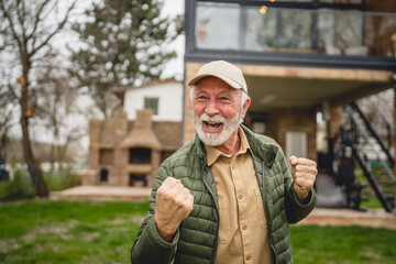 One senior man stand outdoor in front of his house happy confident