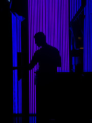 Silhouette in dark room with fluorescent neon lights