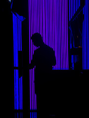 Man silhouette in dark room with fluorescent neon lights