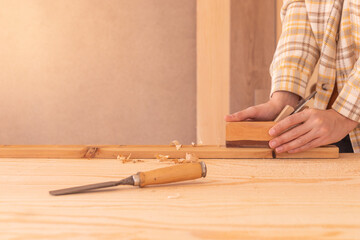 Workman using jack plane on wooden board. Crop faceless male carpenter smoothing wooden detail with...