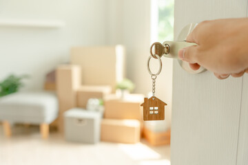 Moving house, relocation. Man hold key house keychain in new apartment. move in new home. Buy or...