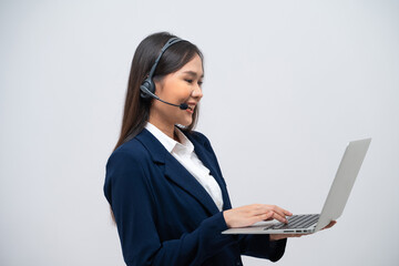 Beautiful Asian call center operator talking with customer using laptop isolated on grey background.