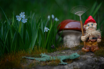 Gnome gardener with a rake.Mushroom meadow with bright flowers.Working gnomes in a fairy...