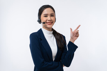Happy young Asian operator woman agent with headsets working in a call center pointing with finger at copy space isolated on white background.
