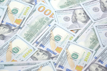 A pile of one hundred US banknotes with president portraits.