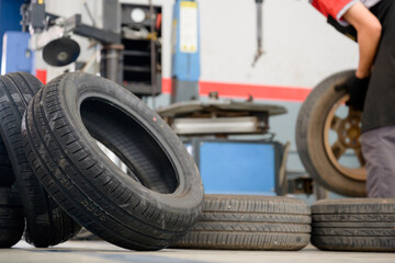 Asian male tire changer Check new tires in stock for replacement at a service center or auto repair...