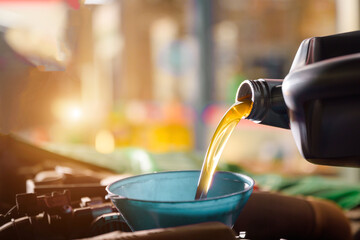 Close-up shot of a mechanic changing new oil to a car At a service center or car oil change shop Car warehouse for the automobile industry