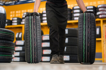 Fototapeta na wymiar A tire changer checks new tires in stock to take them to a service center or wheel shop. Tire warehouse for the automobile industry
