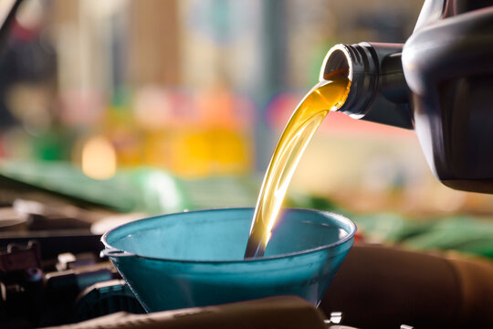 Engine oil Mechanic changing new oil to a car At a service center or car oil change shop Car warehouse for the automobile industry