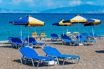 Sunbeds and umbrellas at a beach in Rhodes town in Greece