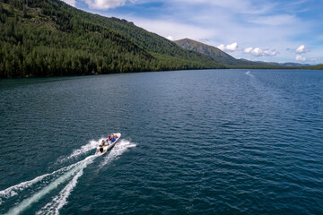 Speed boat move on beautiful Multinskoye lake in mountains Altai, Aerial top view