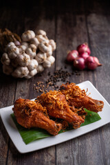 Deep fried chicken and fried onions, southern style herbs recipe on wooden table.