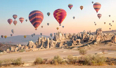 Washable wall murals Pool Hot air balloon flying over rock landscape at Cappadocia - Goreme, Turkey