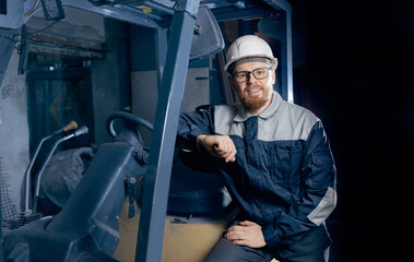 Warehouse, Portrait young man worker with forklift on industry factory, blue color © Parilov