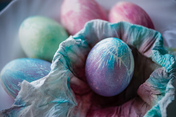 Close up easter eggs painted in monochrome style close up. Tinted in blue and violet color with stains, scuffs, scratches. Handmade painted eggs. Soft focus.