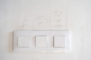 switches with trowel drawing and writing on the wall. words written in pencil to indicate the electrical renovations of the restoration of an old house.