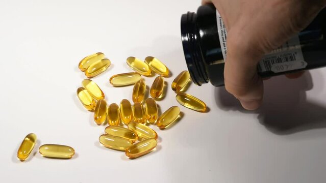 pastiglie di omega 3 rovesciate da un barattolo, medicinali per la salute