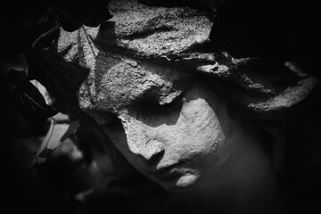 Sad angel. Fragment of ancient statue. Black and white image.