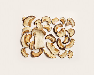 Dry slices of porcini as trend food pattern, square composition from boletus mushrooms, top view, flat lay, beige pastel aesthetic monochrome photo. Gourmet food ingredient, vegetable organic protein