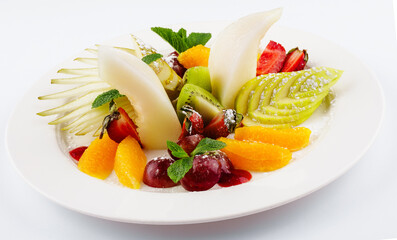 Fresh fruit salad on white plate isolated on white