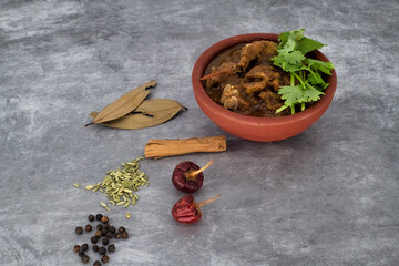 Indian cuisine, Spicy and delicious mutton curry in traditional clay pot. Tasty mutton roast with Indian spices .Mutton masala -Selective focus photograph...
