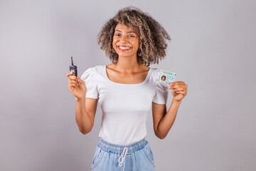 beautiful Brazilian woman, black,.holding driver's license, driver's license and car key.