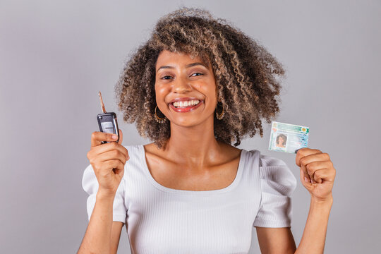 beautiful Brazilian woman, black,.holding driver's license, driver's license and car key.