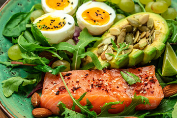 Salmon fillet with fresh salad, grape, eggs and avocado. set of healthy food for keto diet