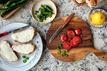 Top view chopped cherry tomatoes and green peppers for making bruschetta with cream cheese.