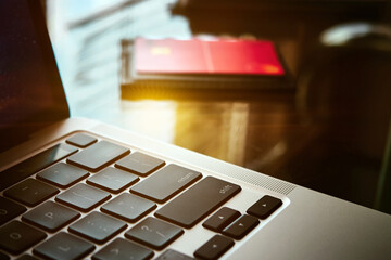 Close-up of an open laptop, a credit bank card and a large cup of coffee on a glass table in the...