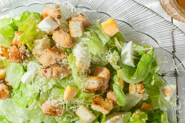 Caesar salad in a glass plate close-up