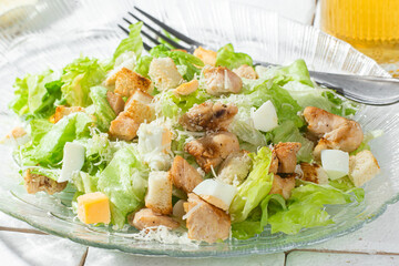 Caesar salad in a glass plate close-up