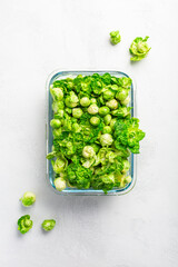 Fresh  organic green brussels sprouts and small winter cabbage vegetable in glass container, ready to freeze