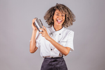 Young black Brazilian woman, cook, masterchef, wearing restaurant uniform. holding cocktail shaker...