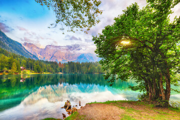 Incredible view of sunset over Fusine lake with Mangart peak on background.