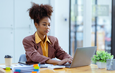 Young African American businesswoman working with pile of documents at office workplace, business finance and accounting concepts.