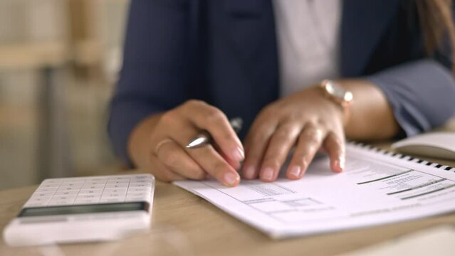 Taxes, paperwork and calculator with woman hands writing budget report, accounting review and debt management. Calculating, financial documents and checklist of accountant or person in finance career