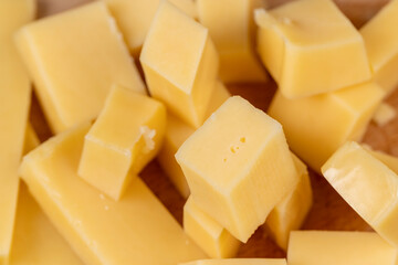 Yellow hard cheese sliced on a board