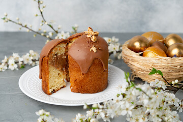 Cut Easter cake on plate decorated with spring flower branches