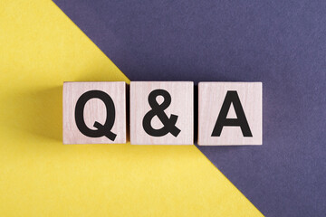 Wooden cube with vocabulary Q and A on gray and yellow background
