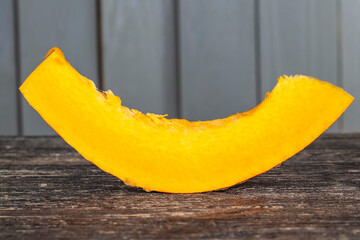 Sweet ripe orange pumpkin is sliced on the table